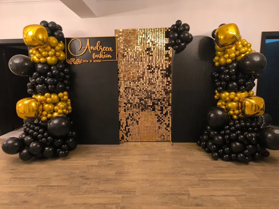 Arcadă de baloane negru cu auriu și panou cu paiete aurii, la deschiderea magazinului Andreea Fashion